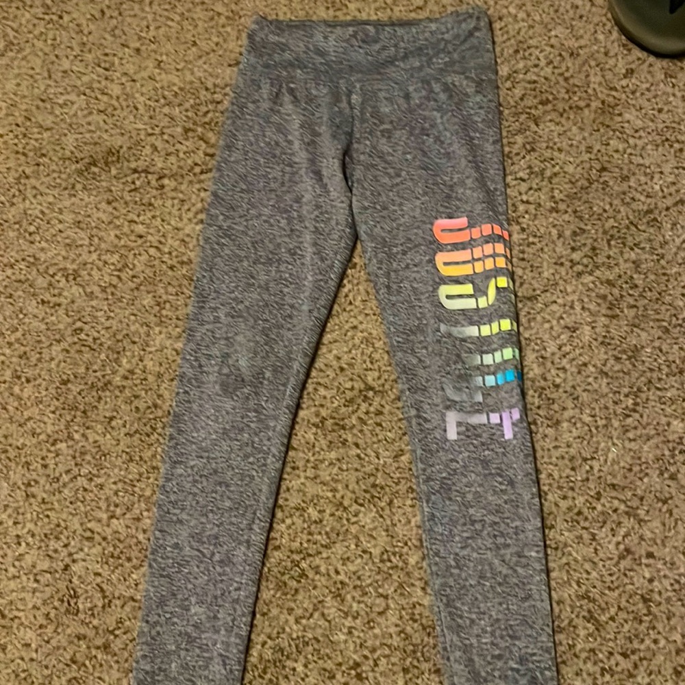 Justice leggings that are gray with rainbow writing